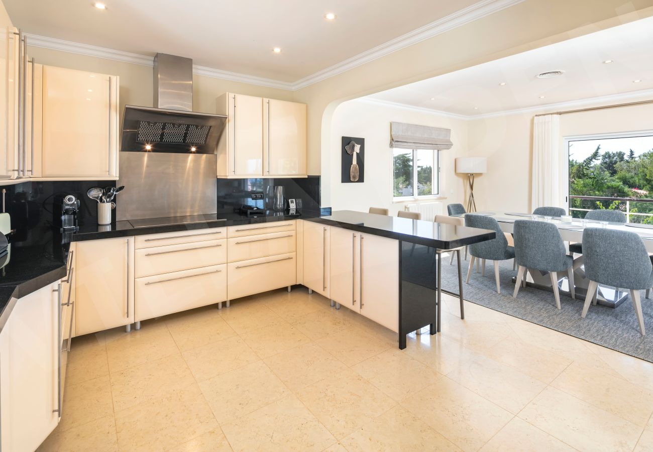 Cozinha moderna com bancadas em granito e sala de jantar na Villa Eden