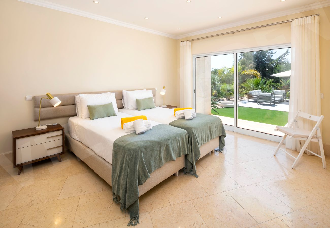 Quarto twin com acesso direto ao jardim e portas de correr na Villa Eden