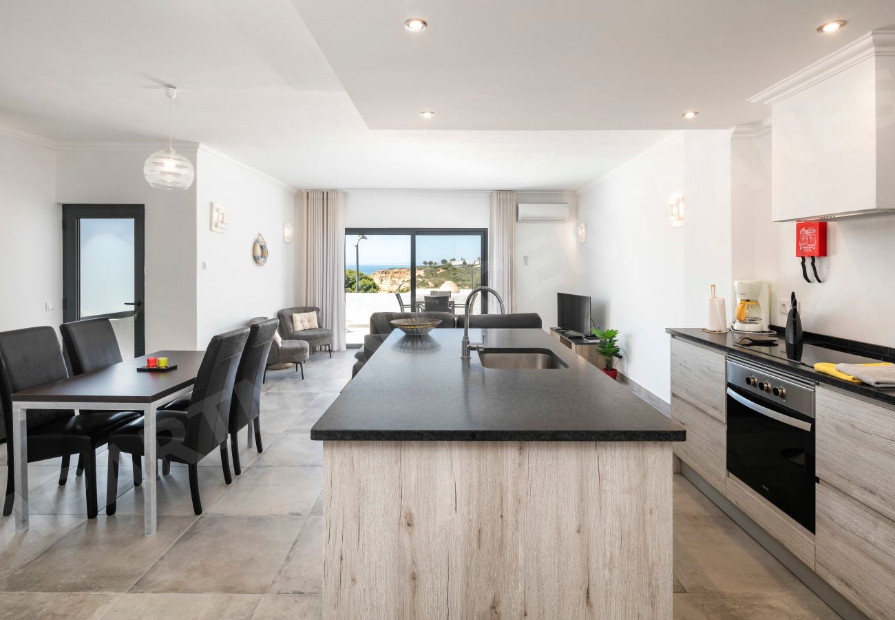Cozinha, sala de jantar e estar em plano aberto com terraço e vista mar