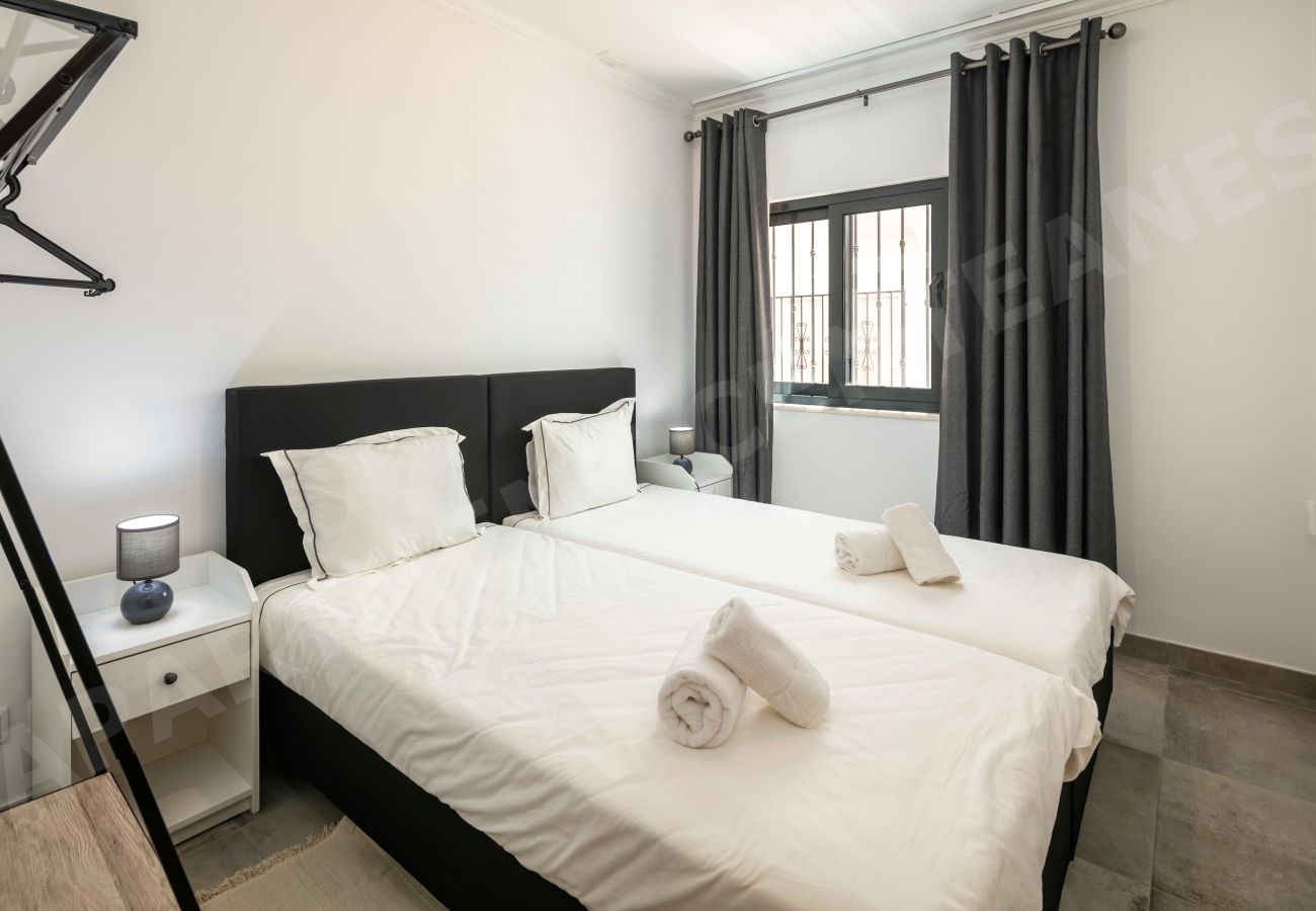 Quarto twin moderno com iluminação suave no Apartamento Centeanes