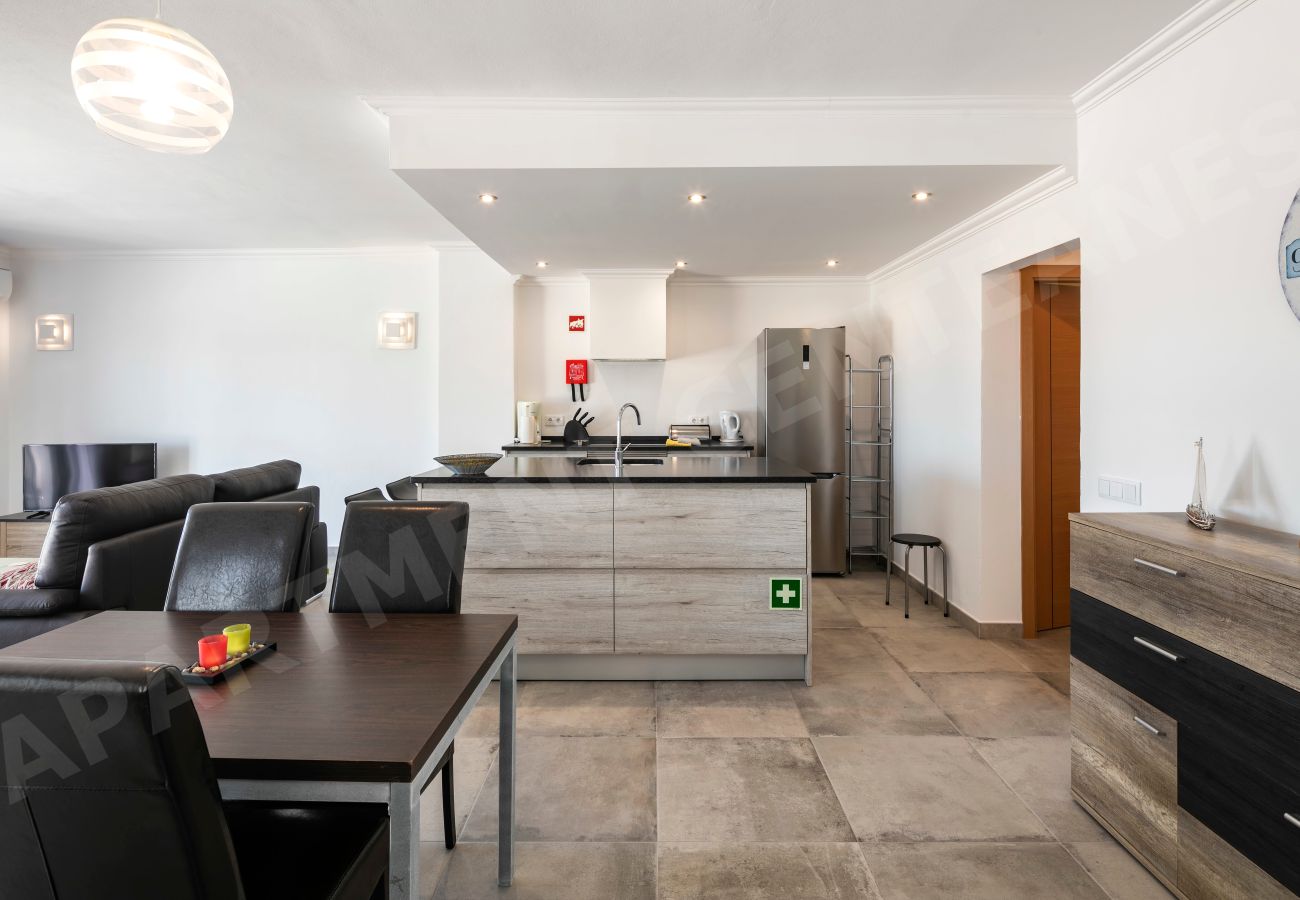 Cozinha moderna com balcão e eletrodomésticos no Apartamento Centeanes