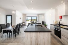 Cozinha, sala de jantar e estar em plano aberto com terraço e vista mar