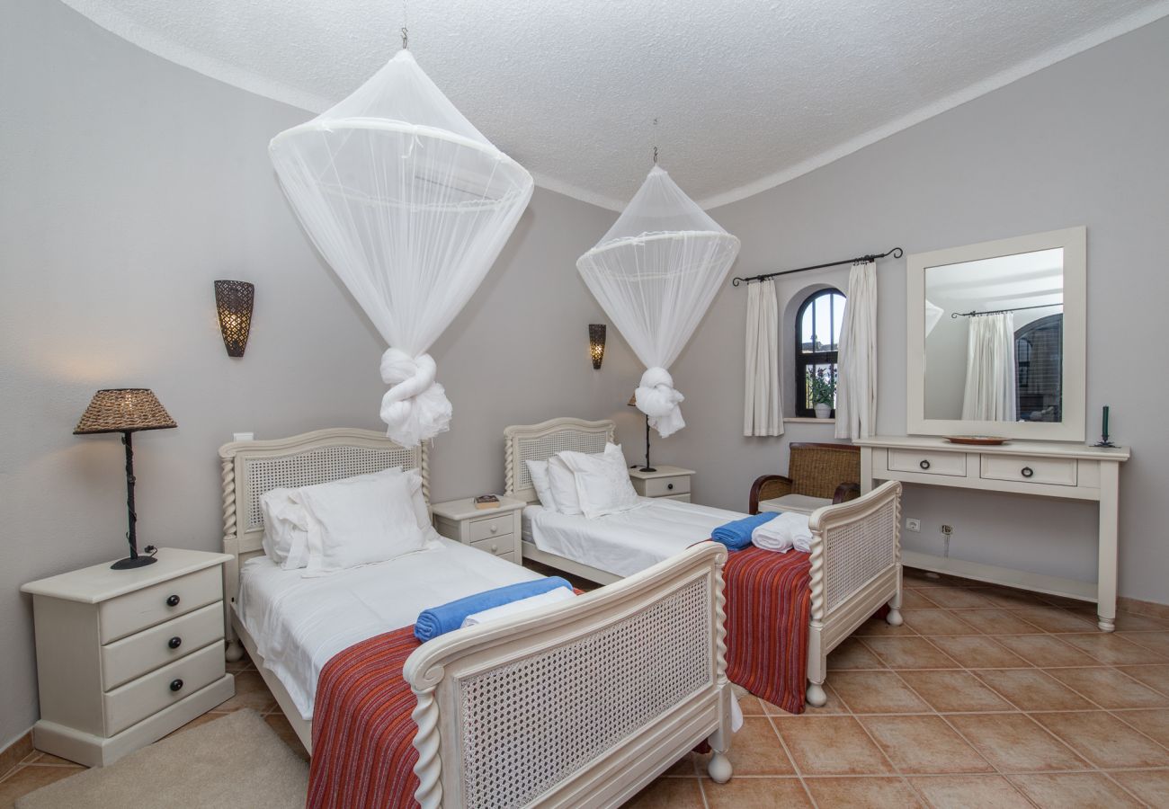 twin bedroom with mosquito nets above beds
