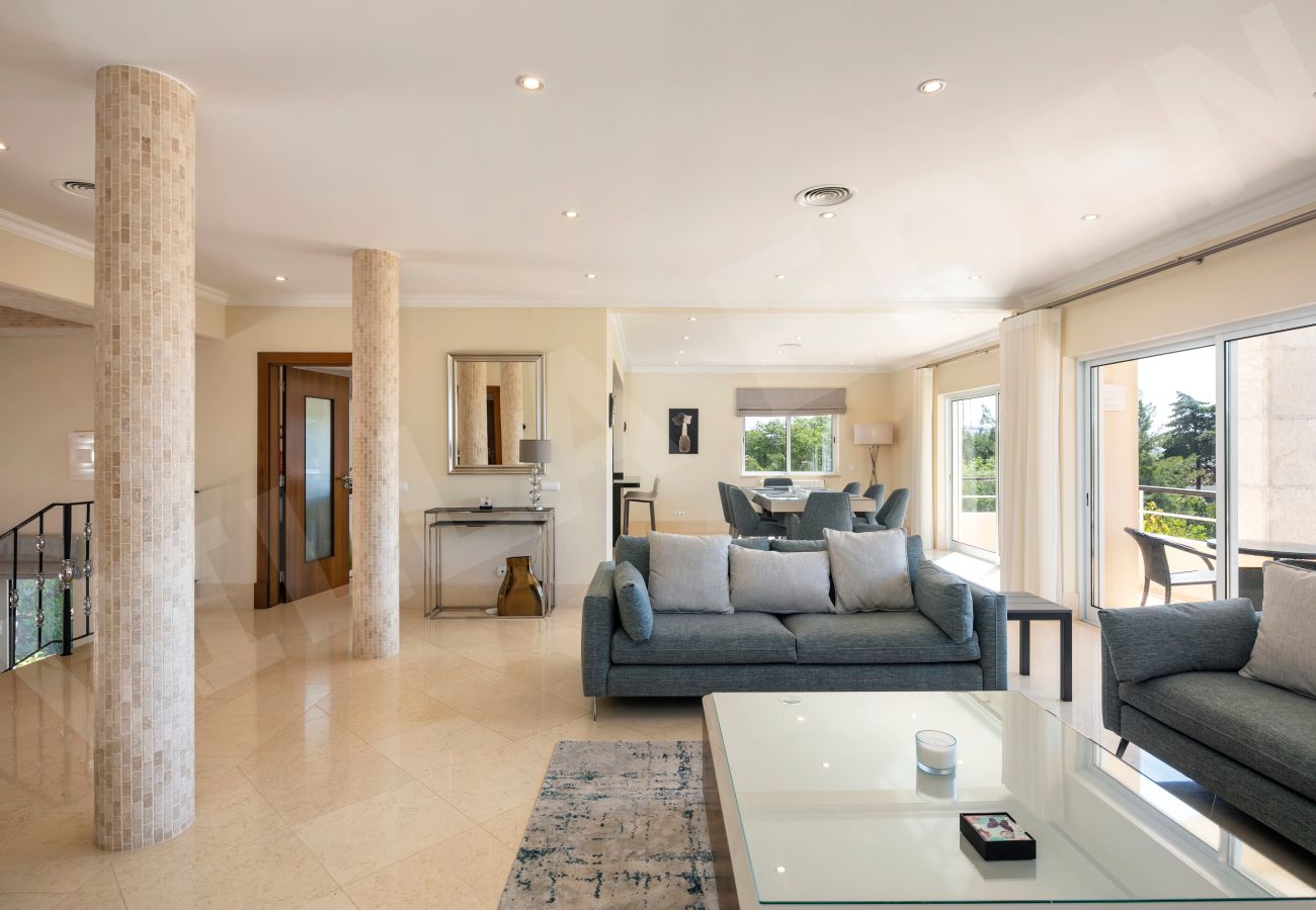Open-plan living and dining space with balcony access at Villa Eden