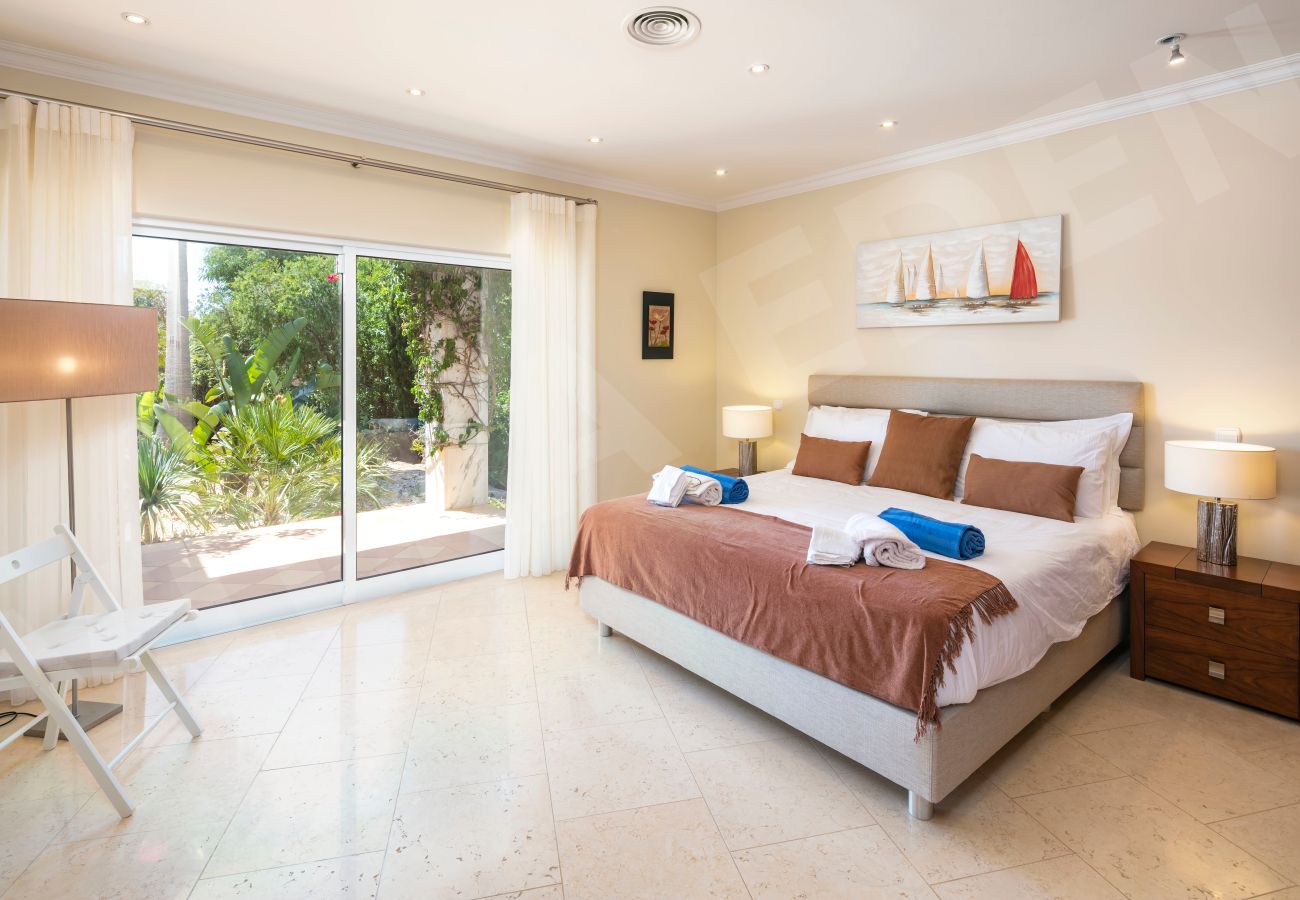 Double bedroom with garden view and outdoor access at Villa Eden in Carvoeiro