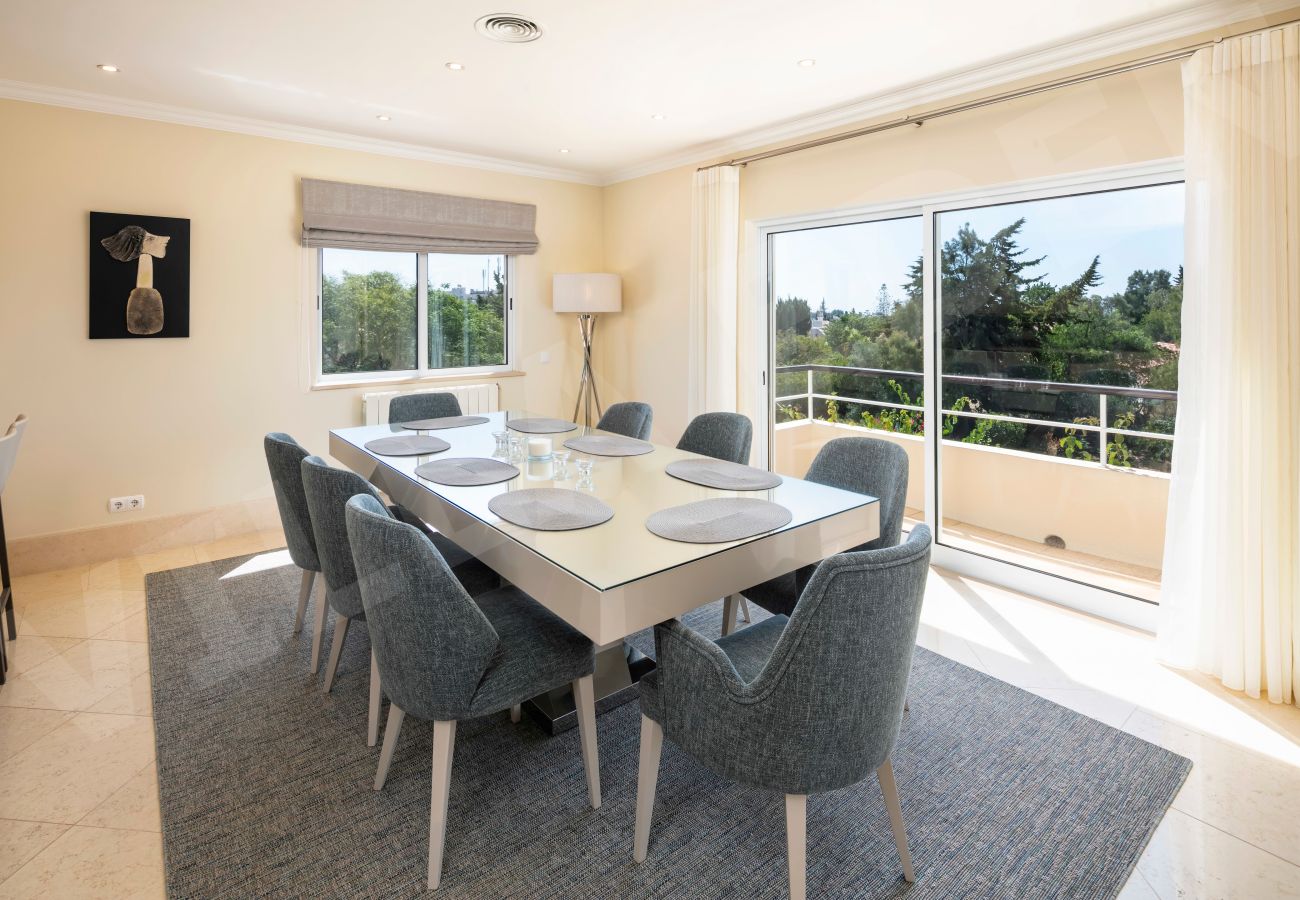 Dining room with balcony access and garden views at Villa Eden in Carvoeiro