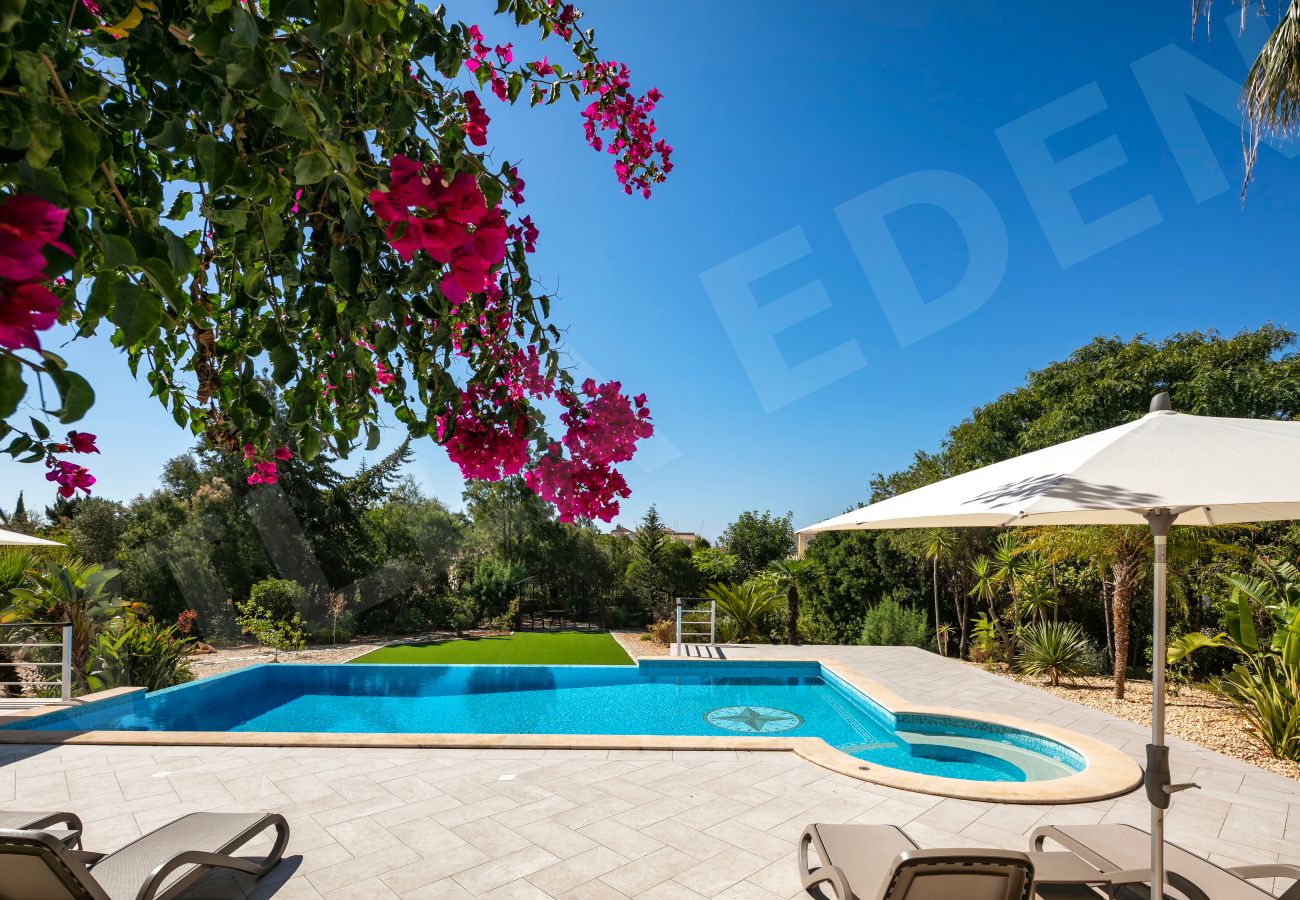 Poolside view with bougainvillea, loungers and Jacuzzi at Villa Eden in Carvoeiro