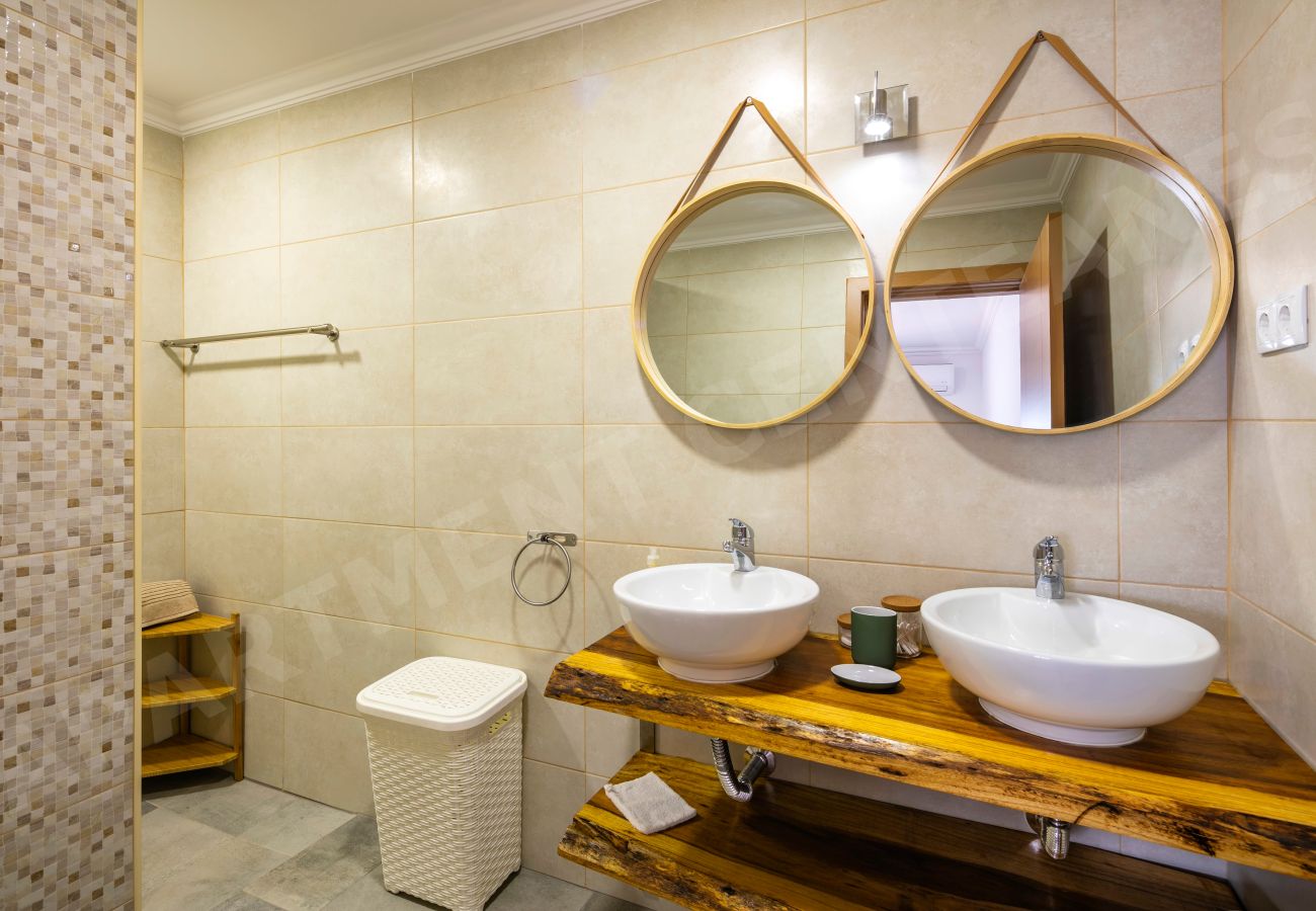 Double sink bathroom with wood vanity in Apartment Centeanes