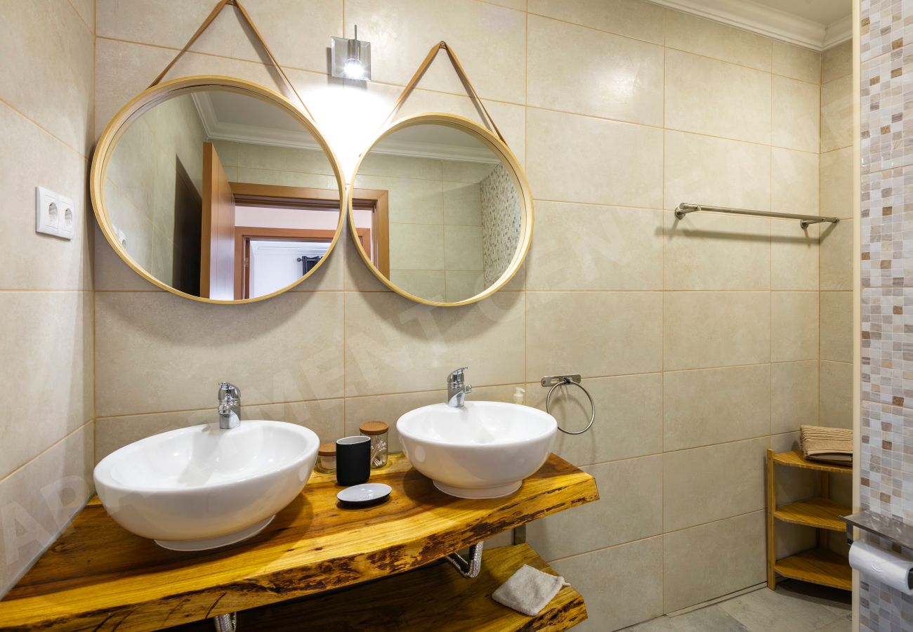 Bathroom with twin round mirrors and double sinks at Apartment Centeanes