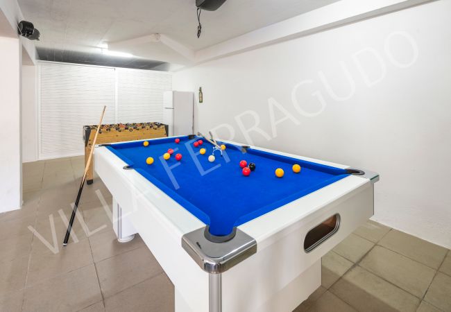 games room with pool table in Villa Ferragudo | Algarve Holiday Lets Modern games room in Villa Ferragudo featuring a blue-felt pool table and a foosball table, perfect for entertainment.