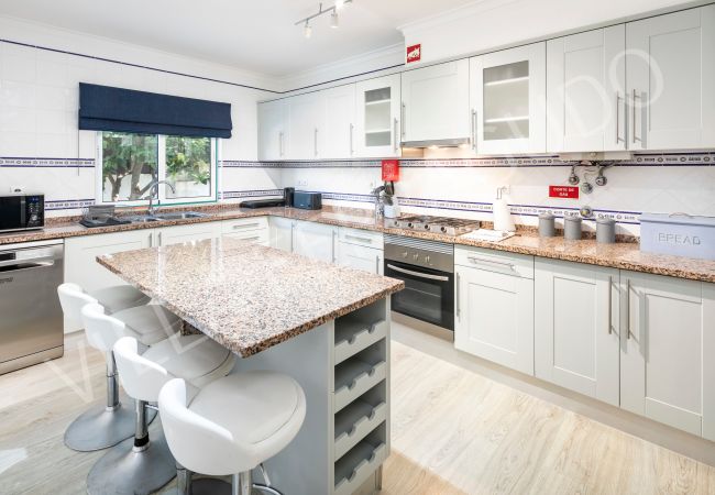 Fully equipped kitchen with island in Ferragudo holiday rental. Villa Ferragudo kitchen with island and garden view.