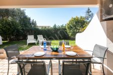 Outdoor dining table set with plates and wine glasses on terrace overlooking garden at 813 Alporchinhos