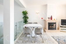 Modern open-plan dining area with white table and grey chairs in Casa do Figos, Luz